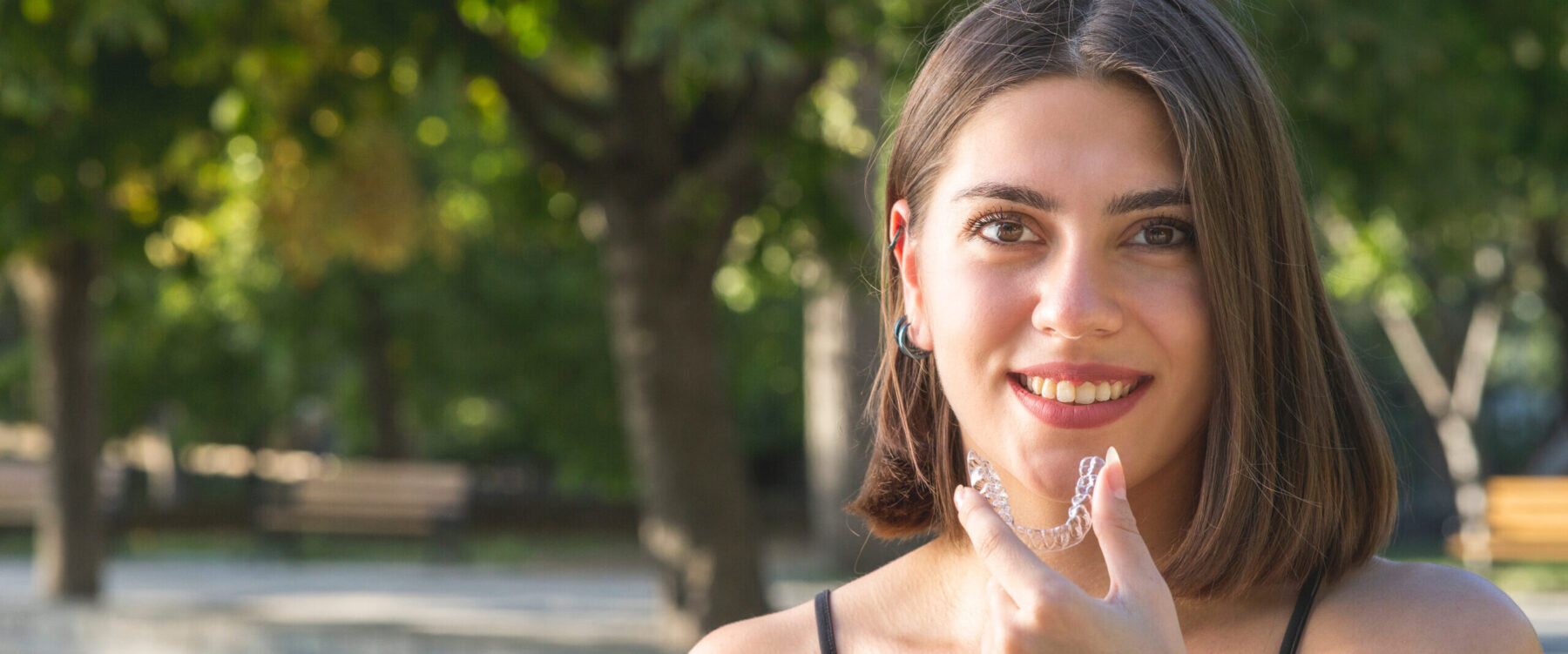 BeautifulSmilingTurkishWomanIsHoldingAnInvisalignBracer | Cambridge Dental Care